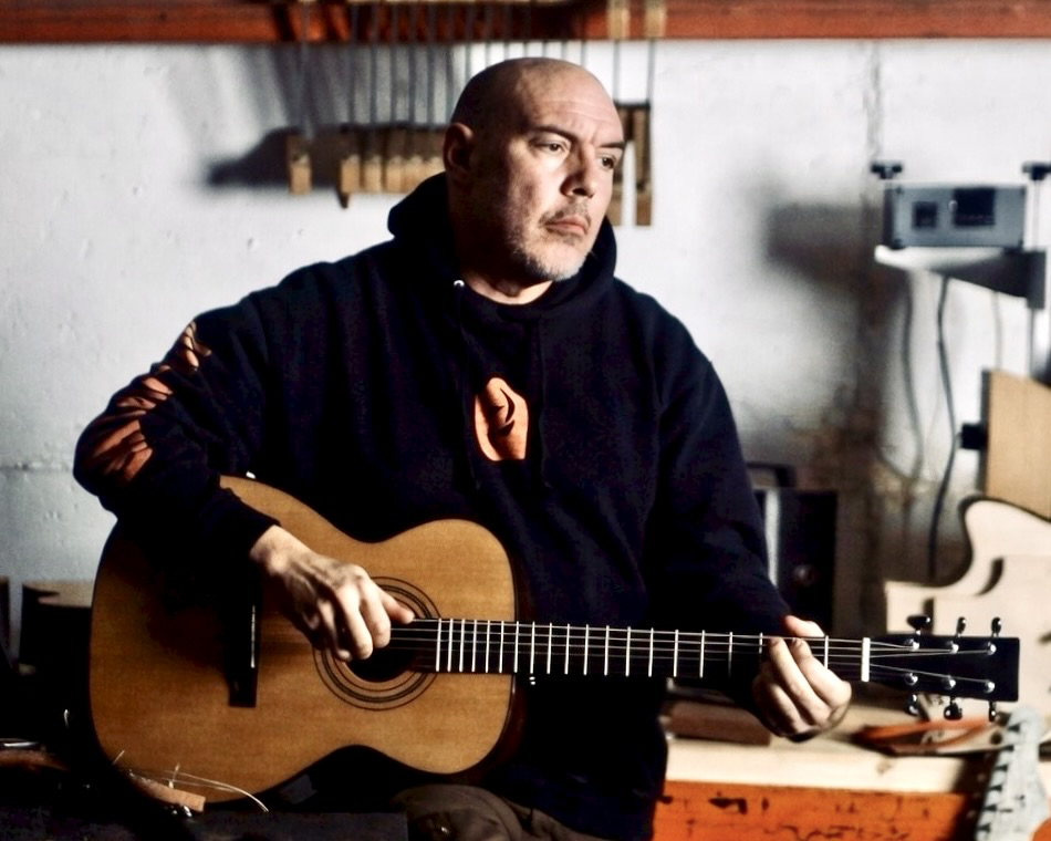 Rick Molloy in the shop with a guitar.